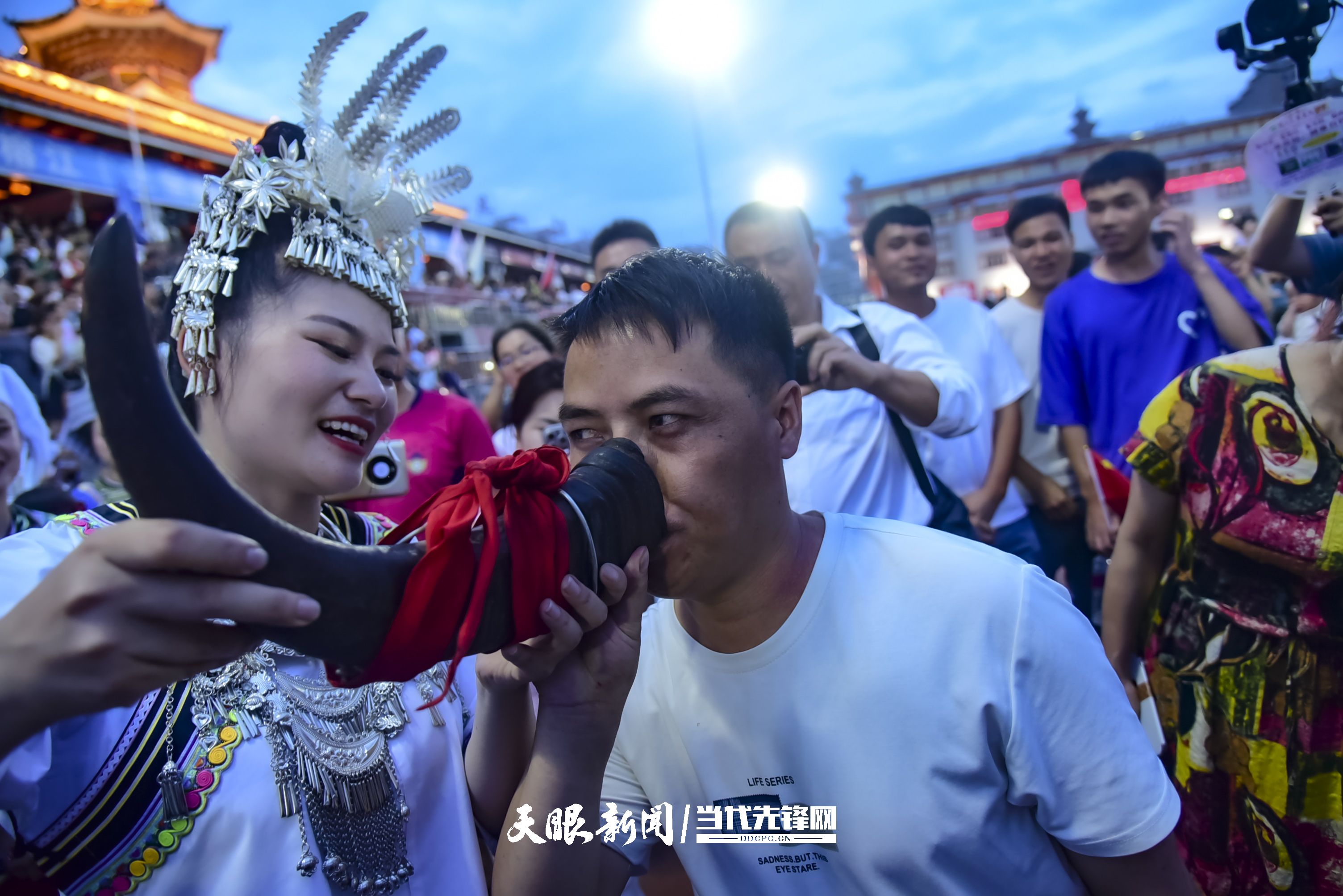 村超現(xiàn)場(chǎng)，當(dāng)?shù)厝罕娤蜻h(yuǎn)道而來(lái)的游客敬酒。 潘邵平 攝.jpg
